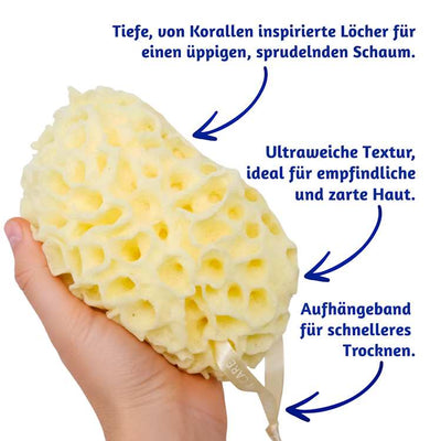 Ein Badeschwamm mit der Aufschrift „Coral Scrubs“ wird in einer Hand gehalten, daneben ein Text auf weißem Hintergrund, der seine Eigenschaften beschreibt.