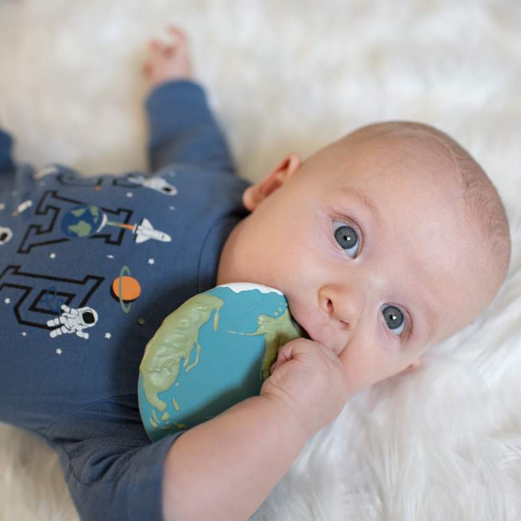 Baby Theo chewing on his Earth Biscuit teething toy soothing his sore teething gums