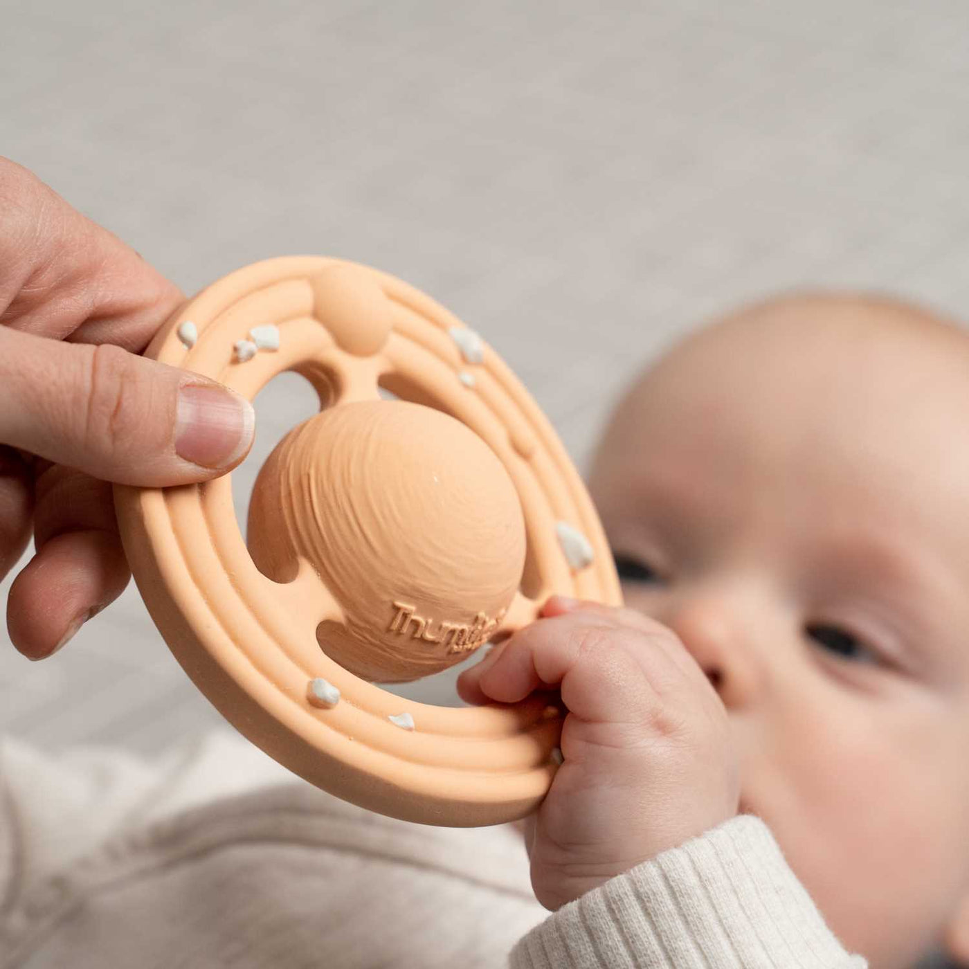 Baby easily grasping a Planet CH3W planet shaped teether