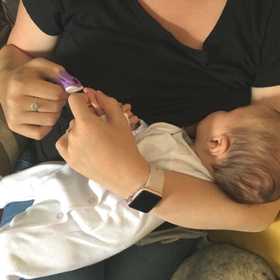 Filing babies nails using Baby Nails Wearable Baby Nail File whilst breastfeeding